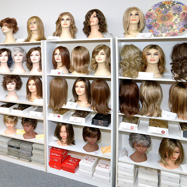 multiple wigs on mannequin heads in store