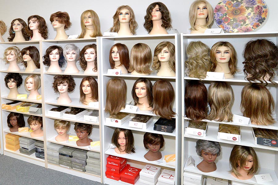 wall of wigs on mannequins
