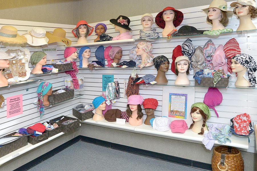 wall of wigs and hats on mannequins
